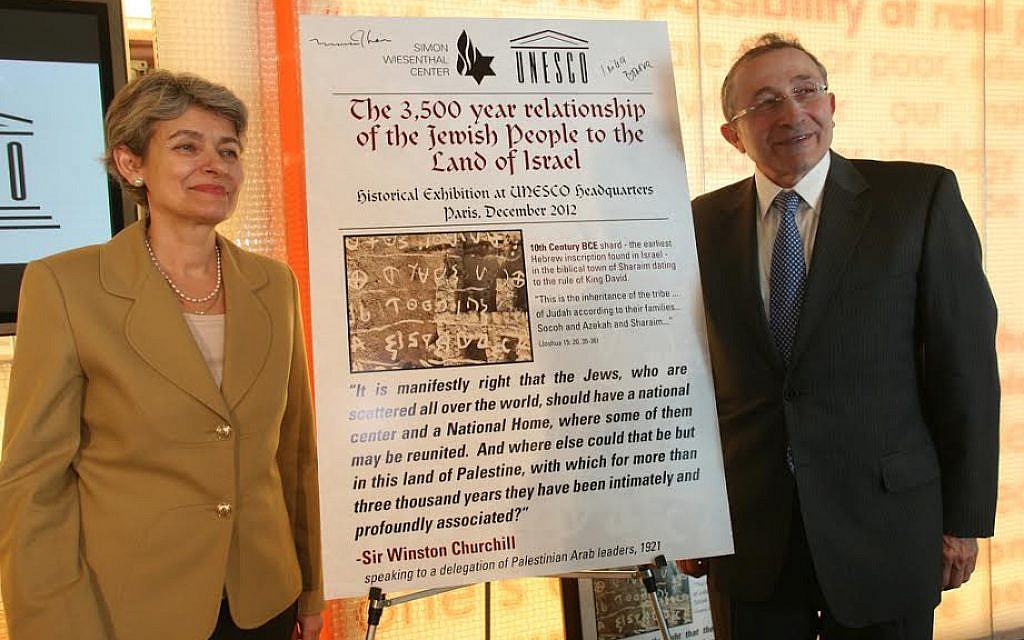 UNESCO's Director General Irina Bokova poses with the Simon Wiesenthal Center's Rabbi Marvin Hier and the original poster for the exhibit on the Jewish people's 3,500-year connection to the land of Israel, in January, 2014. (photo credit: Courtesy Simon Wiesenthal Center)