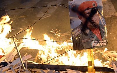 A poster of Venezuelan late President Hugo Chavez remains near a burning barricade during an anti-government demo, in Caracas on February 21, 2014. (photo credit: AFP/Leo Ramirez)