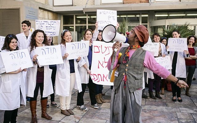 Nurses and a clown protesting outside Hadassah Ein Kerem Hospital in 2014 (photo credit: Flash90)