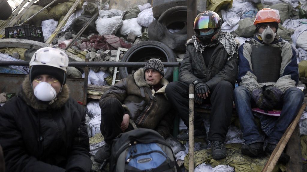 Anti-government protesters take a break on a barricade at Independence Square in Kiev, Ukraine, Friday, Feb. 21, 2014 (photo credit: AP/ Marko Drobnjakovic)