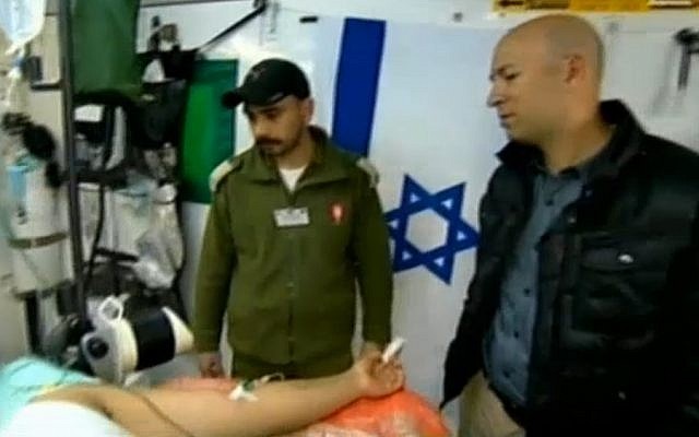 Israeli soldiers treat a wounded Syrian man at a secret military field hospital in the Golan Heights. (photo credit: screen capture, Channel 2)