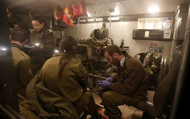 Israeli military medics examine comrades in an ambulance near Har Dov, on Israel's northern border with Lebanon, March 14, 2014 (photo credit: AFP/Jalaa Marey)