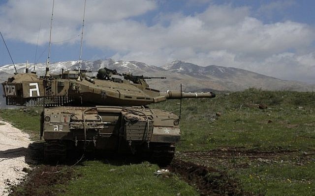 An Israeli army tank is seen stationed near the Golan Heights village of Majdal Shams, March 19, 2014. (AFP/Jalaa Marey/File)