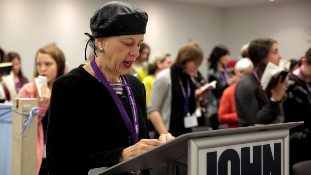 Illustrative: A woman leads a partnership minyan at a conference in New York of the Jewish Orthodox Feminist Alliance (JOFA), December 2013. (Mike Kelly/JTA)