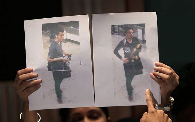 Pictures of two Iranian men who boarded the now missing Malaysia Airlines jet MH370 with stolen passports, held up by a Malaysian policewoman during a press conference, on Tuesday, March 11, 2014 in Sepang, Malaysia. (photo credit: AP Photo/Wong Maye-E)