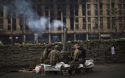 Anti-Yanukovych protesters wearing fatigues guard a barricade in Kiev's Independence Square, the epicenter of the country's current unrest, Ukraine, on Saturday, March 1, 2014. (photo credit: AP Photo/Emilio Morenatti)