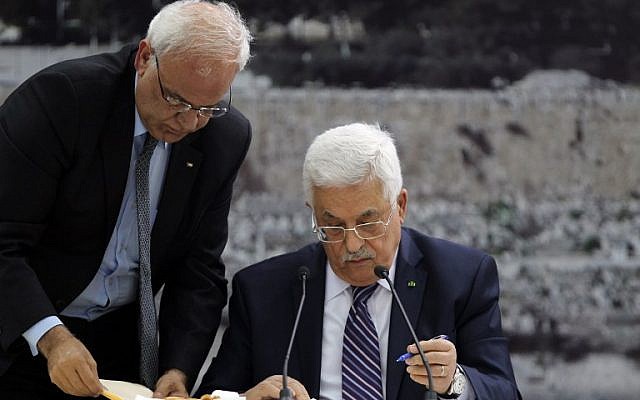Palestinian Authority President Mahmoud Abbas (R) signs a request to join 15 United Nations-linked and other international treaties at his headquarters in the West Bank city of Ramallah on Tuesday, April 1, 2014 (photo credit: AFP/Abbas Monami)