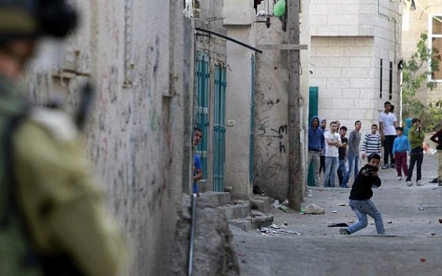 A Palestinian protester uses a slingshot to hurl stones towards Israeli security forces during clashes at the Aida Palestinian refugee camp near Bethlehem on April 14, 2014. (Musa al-Shaer/AFP)