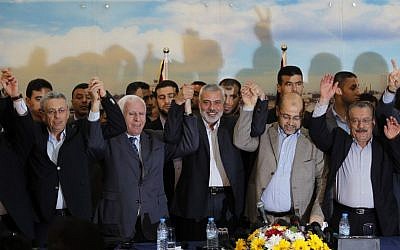 File: From left: Palestinian legislator Mustafa Barghouti, Palestinian Fatah delegation chief Azzam al-Ahmed, Hamas prime minister in the Gaza Strip Ismail Haniyeh, Hamas deputy leader Musa Abu Marzuk, and secretary-general of the Palestinian Arab Front Jameel Shehadeh, pose for a picture in Gaza on April 23, 2014 after announcing a unity deal. (photo credit:AFP/SAID KHATIB)
