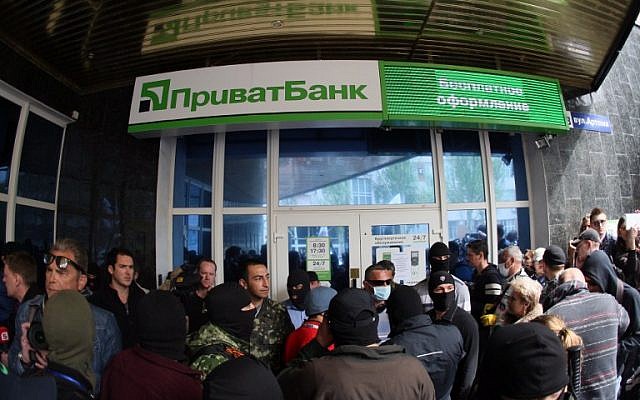 Pro-Russian militants attack a branch of Ukrainian bank Privatbank in the eastern Ukrainian city of Donetsk on Monday, April 28, 2014 (photo credit: AFP/ALEXANDER KHUDOTEPLY)