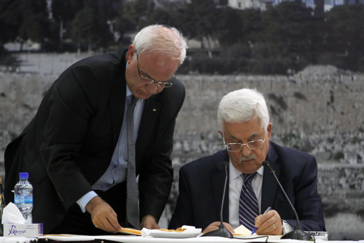 Palestinian President Mahmoud Abbas (R) and Palestinian chief peace negotiator Saeb Erekat, signs an application to  UN agencies in the West Bank city of Ramallah, Tuesday, April 1, 2014. (photo credit: Issam Rimawi/Flash90)