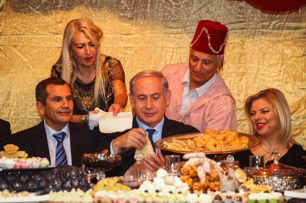 Prime Minister Benjamin Netanyahu, center, and his wife Sara attend the Jewish Moroccan celebration of Maimouna, in Or Akiva on April 21, 2014. (photo credit: Avishag Shaar Yashuv/Flash90/Pool)