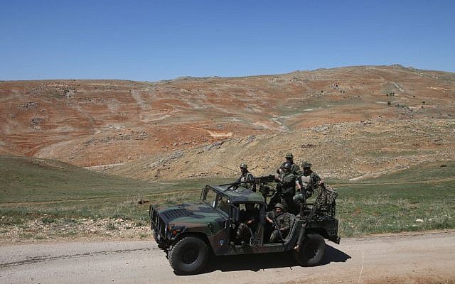In this picture taken on Tuesday, April 22, 2014, Lebanese army soldiers patrol a road near Ras al-Haref mountain at the unmarked Lebanese-Syrian border, eastern Lebanon. (photo credit: AP/Hussein Malla)