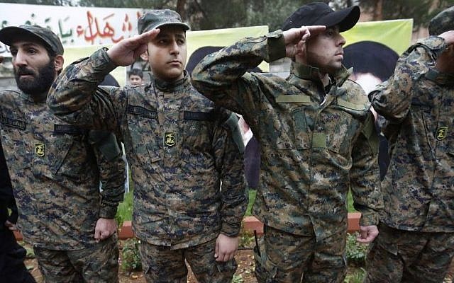 Hezbollah fighters salute during the funeral procession of Hassan al-Laqis, a senior commander of Hezbollah, who was gunned down at his hometown in Baalbek, Lebanon, on December 4, 2013, (photo credit: AP/Hussein Malla)