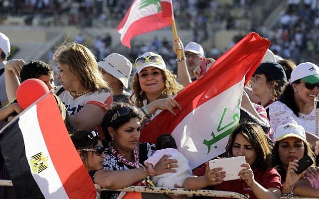 Iraqi Christians greet Pope Francis before a mass at the Amman stadium in the Jordanian capital on May 24, 2014. Pope Francis made an urgent plea today for peace in war-torn Syria as he kicked off a three-day pilgrimage to the Middle East. (Photo credit: AFP/Khalil Mazraawi)