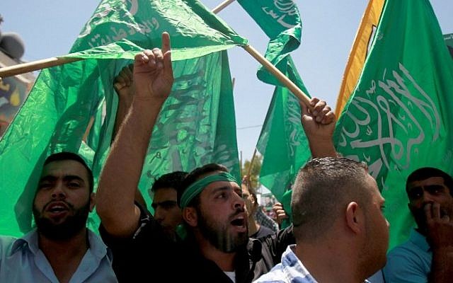 Palestinians in the West Bank wave green Hamas flags during a demonstration in support of Palestinian prisoners on hunger strike in Israeli jails on May 30, 2014. (photo credit: Musa al-Shaer/AFP)