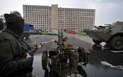 Pro-Russian fighters take their positions before storming the regional state building in the eastern Ukrainian city of Donetsk on May 29, 2014. (photo credit: AFP/ VIKTOR DRACHEV)