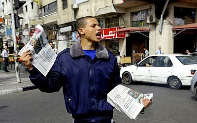A Palestinian vendor shouts as he sells Al-Quds Newspaper on the first day of its arrival to Gaza from the West bank since being banned by Hamas in 2008, in Gaza City, in the northern Gaza Strip, Wednesday, May 7, 2014. (photo credit: AP Photo/Adel Hana)