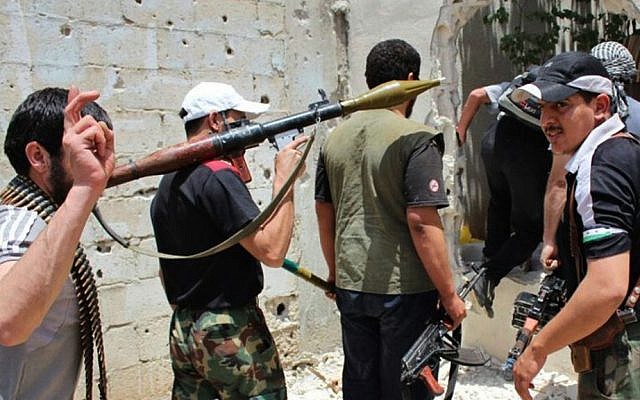 Syrian rebels of unknown affiliation hold their weapons as they prepare to fight against Assad regime troops in Homs province, June 18, 2012 (photo credit: AP/File)