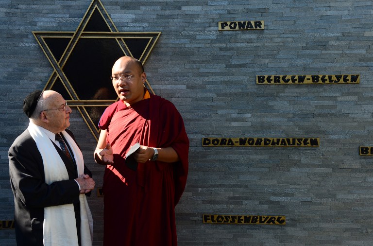 Rabbi Tovia Ben-Chorin (L), leader of Berlin's Jewish community, chats with the 17th Karmapa Ogyen Trinley Dorje (R) following talks at a Synagogue in Berlin on June 7, 2014 (photo credit: AFP/JOHN MACDOUGALL)