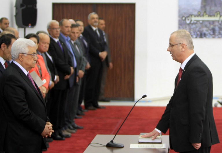 Palestinian Prime Minister Rami Hamdallah (R) is sworn in along with the new Palestinian unity government in the presence of PA President Mahmud Abbas (L) in the West Bank city of Ramallah, Monday, June 2, 2014 (photo credit: AFP/ABBAS MOMANI)