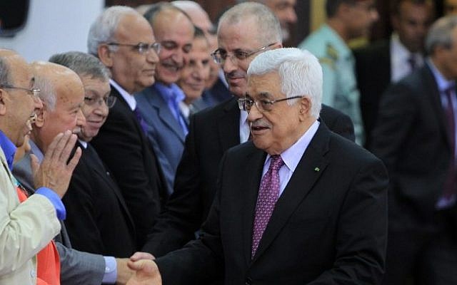 Palestinian Authority President Mahmoud Abbas and Prime Minister Rami Hamdallah greet the members of the new Palestinian unity government in the West Bank city of Ramallah, June 2, 2014. (Photo credit: AFP /ABBAS MOMANI)