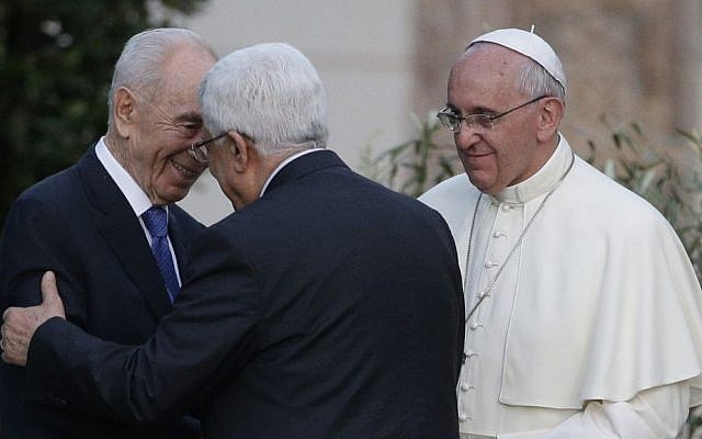 Pope Francis looks on as Israel's then-president Shimon Peres (left), and Palestinian Authority President Mahmoud Abbas greet each other during an evening of peace prayers in the Vatican gardens, Sunday, June 8, 2014. (photo credit: AP/Gregorio Borgia)