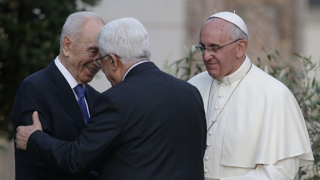 Pope Francis looks on as Israel's President Shimon Peres, left, and Palestinian Authority President Mahmoud Abbas greet each other during an evening of peace prayers in the Vatican gardens, Sunday, June 8, 2014. (photo credit: AP Photo/Gregorio Borgia)