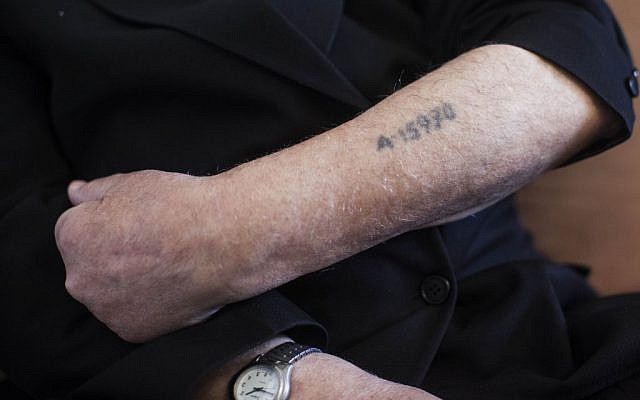 A Holocaust survivor shows his prisoner number tattooed on his arm. (Yonatan Sindel/Flash90)