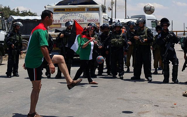 Illustrative photo of Palestinians playing soccer while rallying for hunger-striking prisoners outside Ofer Prison in the West Bank, on June 11, 2014. (Issam Rimawi/Flash90)