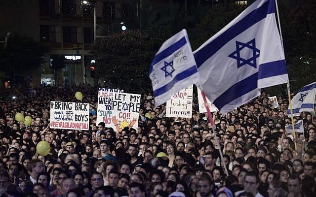 Israelis hold signs during a rally calling for the release of of three kidnapped teenagers -- Eyal Yifrach, Gil-ad Shaar and Naftali Fraenkel -- in Tel Aviv, Sunday, June 29, 2014. (Photo credit: Tomer Neuberg/Flash90)