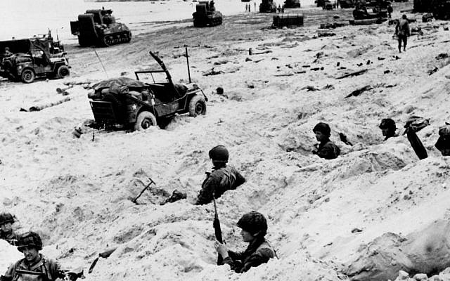 This June 6, 1944, file photo shows American soldiers of the Allied Expeditionary Force securing a beachhead during initial landing operations at Normandy, France. (AP Photo/Weston Haynes, File)