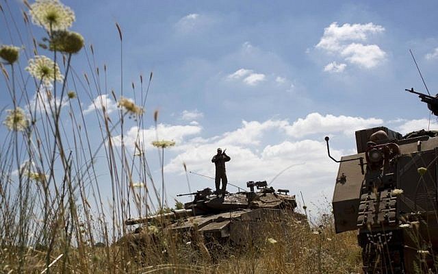 Israeli soldiers work on their tank following the first death on the Israeli side of the Golan since the Syrian civil war erupted more than three years ago, near the Israeli village of Alonei Habashan, close to the Quneitra border crossing, Sunday, June 22, 2014. (AP Photo/Oded Balilty)
