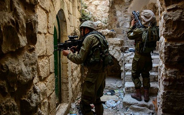 Illustrative photo of Israeli soldiers on an arrest operation in the West Bank city of Hebron, June 2014. (IDF Spokesperson/Flash90)