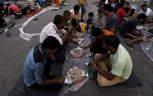 Muslim Gazans gather for an Iftar meal at a Greek Orthodox church in Gaza City where many Palestinians have sought taking shelter, Friday, July 25, 2014. (photo credit: Mohammed Abed/AFP)