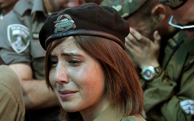 Israeli soldiers and friends mourn during the funeral of Israeli soldier Cpl. Meidan Maymon Biton, 20, at the cemetery of the southern Israeli city of Netivot on July 29, 2014. Meidan was killed the previous day when a mortar shell fired from the Gaza Strip hit the Eshkol regional council (Photo credit: Gil Cohen-Magen/AFP)