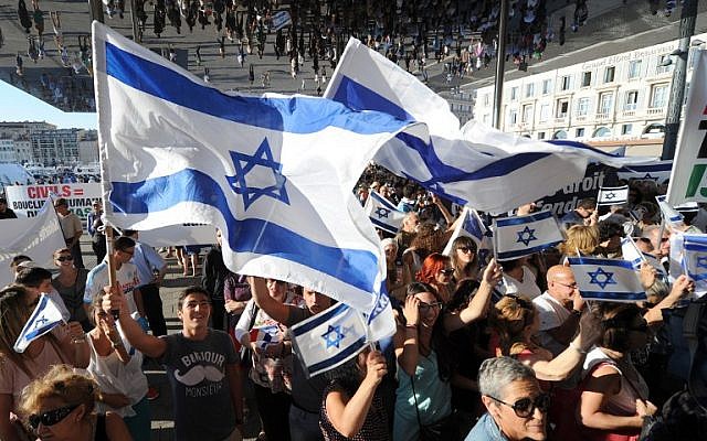 People wave Israeli flags as they take part in a demonstration supporting Israel on July 27, 2014, in Marseille, southeastern France. (photo credit: AFP PHOTO / BORIS HORVAT)