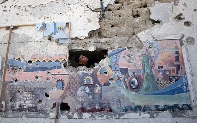 A Palestinian man inspects the damage at a UN school in the Jabaliya refugee camp in the northern Gaza Strip, July 30, 2014. (photo credit: AFP/Mahmud Hams)