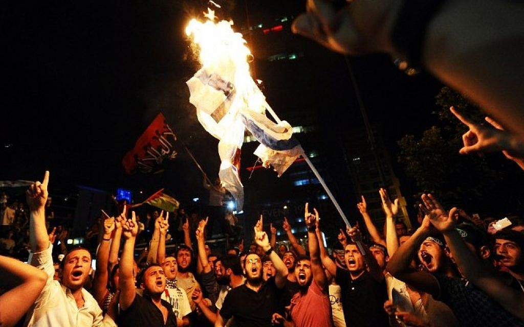 Turkish protestors set fire to an Israeli flag while shouting slogans during a demonstration against the Israeli military operation in Gaza, Saturday, July 19, 2014 in front of the Israeli Consulate in Istanbul. (photo credit: Ozan Kose/AFP)