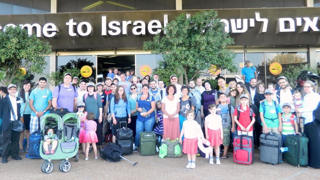 A group photo of the 64 olim who arrived in Israel Tuesday, July 8, 2014, after the commencement of Operation Protective Edge in the Gaza Strip.  (photo credit: Sasson Tiram/Nefesh B'Nefesh)