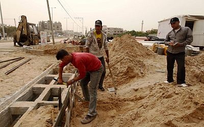 In this Monday, April 8, 2013 photo, Palestinians work on a Qatar-funded road in Gaza City photo credit: AP/Hatem Moussa)