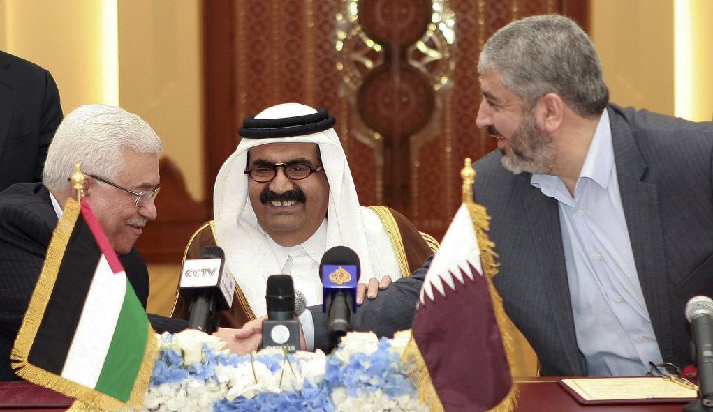 Palestinian President Mahmoud Abbas, left, shakes hands with Hamas leader Khaled Mashaal, right, as the Emir of Qatar, Sheikh Hamad bin Khalifa Al Thani, center, looks on, after signing an agreement in Doha, Qatar, Monday, Feb 6, 2012 (photo credit: AP/Osama Faisal)