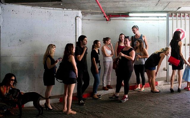 Israelis take cover in an underground parking garage as siren sounds during rocket attack fired by Palestinian militants from Gaza in Tel Aviv, Israel, Thursday, July 10, 2014. (photo credit: AP/Oded Balilty)