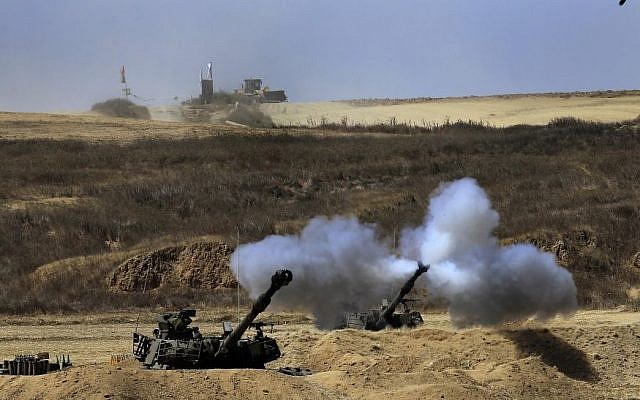 An Israeli tank fires towards Gaza, near the Israel and Gaza border on the morning of Sunday, July 27, 2014. (Photo credit: AP/Tsafrir Abayov)