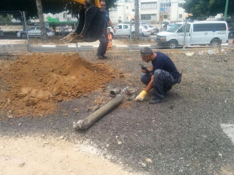 Sappers examine a rocket fired at the coastal city of Ashkelon, Sunday, July 13, 2014 (photo credit: Israel Police/Twitter)