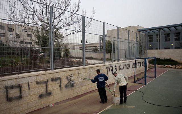 Workers clean the graffiti at the Jewish-Arab bilingual school in Jerusalem stating 'death to Arabs' and 'Kahana was right,' Feb 7, 2012 (Flash90)