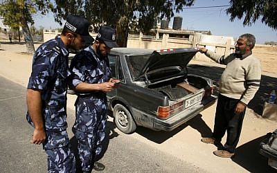 A Hamas security officers checks IDs after stopping a car at a checkpoint on the outskirts of the border between Rafah and Israel to prevent Palestinian collaborators from escaping into Israel, April 15, 2013 (Abed Rahim Khatib/Flash90)