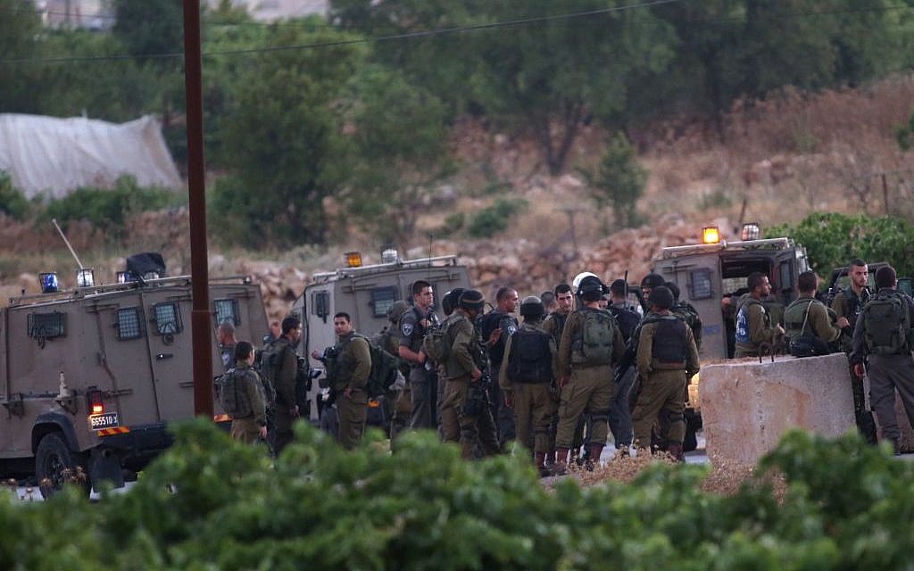 IDF soldiers assemble in the Palestinian village of Halhul, north of Hebron, after the bodies of three Israeli teenagers were found nearby, Monday, June 30, 2014. (photo credit: Nati Shohat/Flash90)