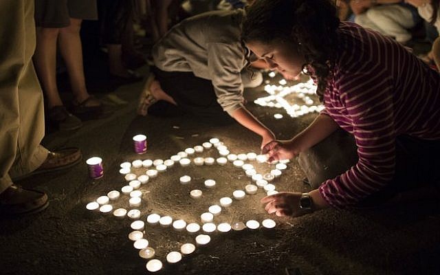 In this June 30, 2014 photo, citizens are seen lighting candles at the hitchhiking site in the West Bank from where three young Jewish teenagers, Eyal Yifrach, Naftali Fraenkel and Gilad Sha'ar were abducted on June 12. (Photo credit: Yonatan Sindel/FLASH90)
