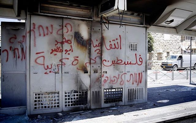 Graffiti reading 'Price Tag. Death to Jews' is seen spray-painted on what remains of a Light Rail station which has been vandalized by Palestinians in the Arab neighborhood of Shuafat, Jerusalem, July 2014. (photo credit: Sliman Khader/Flash90)